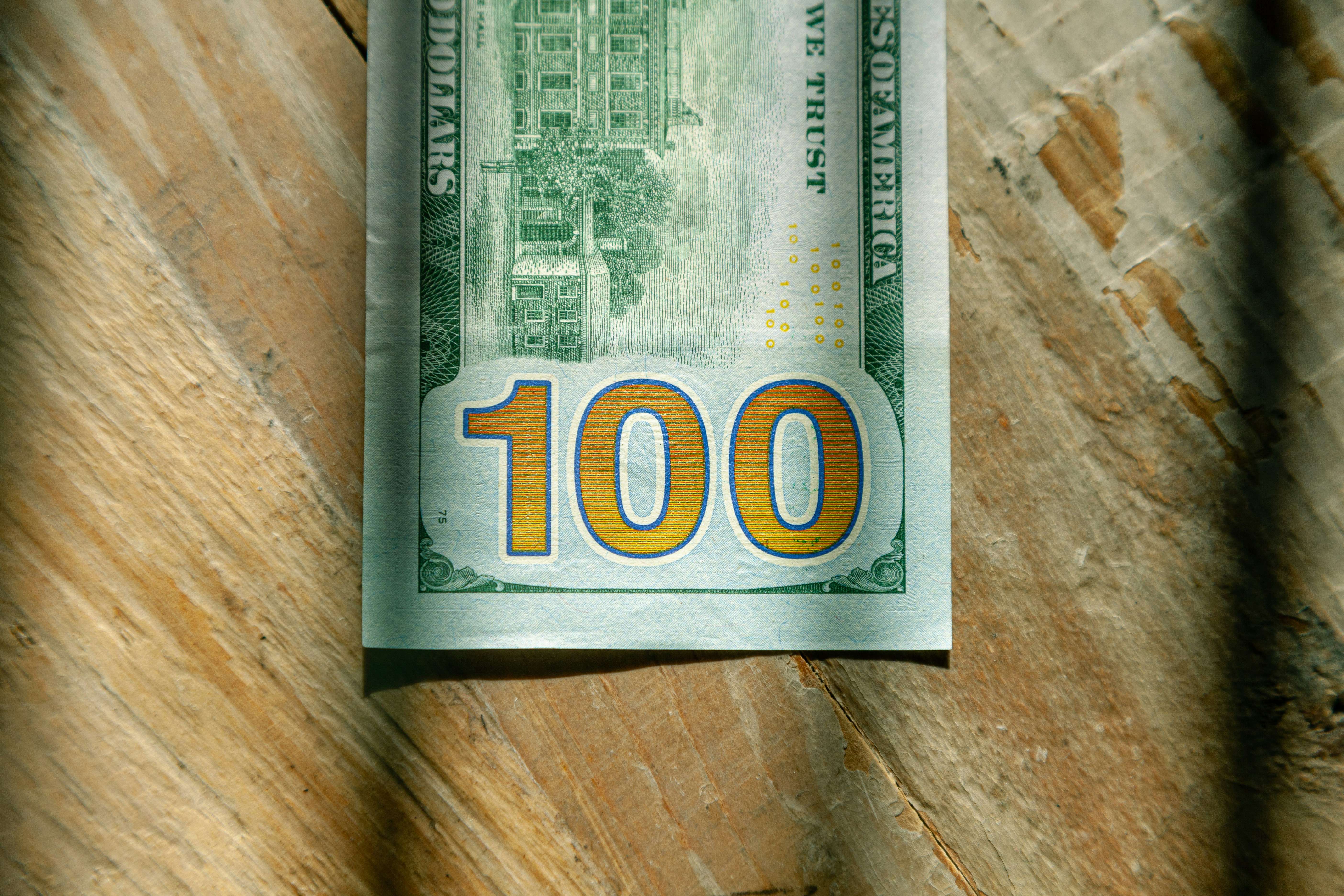 US Currency One hundred dollar bill flat lay on wood background